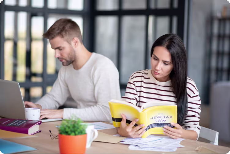 Staff Pay 1 Two people researching staff pay by a desk